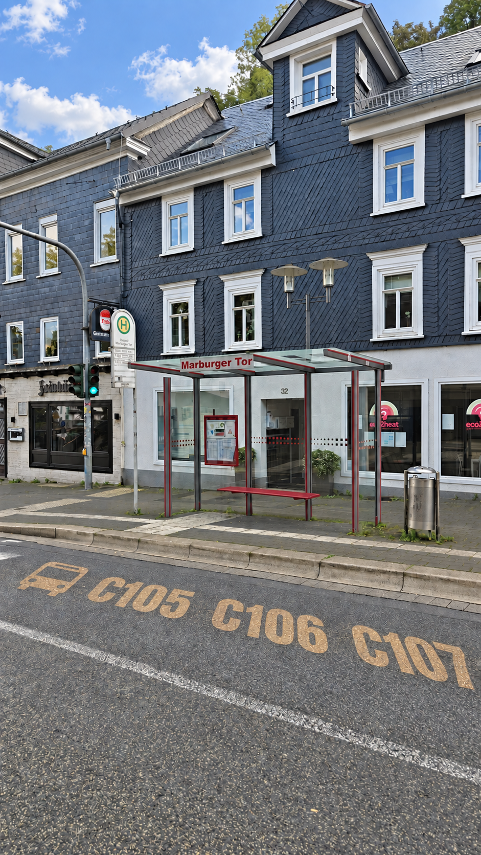Die Haltestelle liegt auf der anderen Straßenseite. Die bronzenen Liniennummern im Bild dienen zur Orientierung.